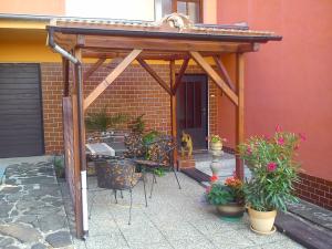 a wooden pergola with a table and chairs and plants at Apartments České Středohoří in Teplice