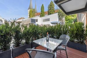 un tavolo e delle sedie su un balcone con un edificio di GLANDON Rooms Haldenhof - Self-Check-In a Lucerna
