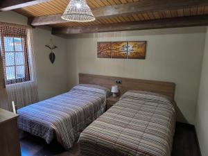 two beds sitting in a room with at Casa Miravalles Fornela in Guimara