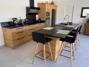 a kitchen with a black counter top and wooden cabinets at La bastide de marie in Robion en Luberon