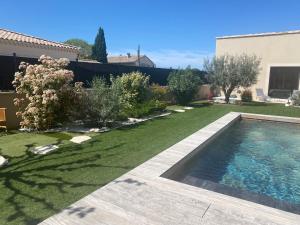 a backyard with a swimming pool and a lawn at La bastide de marie in Robion en Luberon