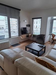 a living room with a couch and a coffee table at Lichtrijk en comfortabel hoekappartement met gratis parking en zeer centraal gelegen - Comme Chez Soi in Ostend