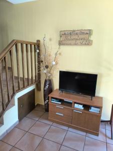 a living room with a flat screen tv on a wooden cabinet at Casa Miravalles Fornela in Guimara