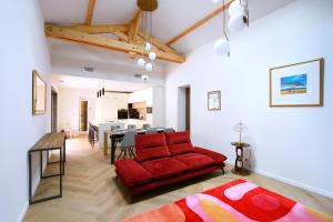 a living room with a red couch and a dining room at Le Clos des Izards in Périgueux +13 photos
