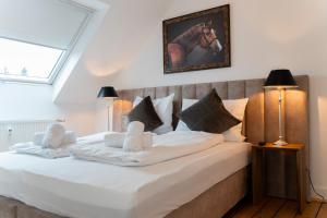 ein Schlafzimmer mit einem großen weißen Bett mit zwei Kissen in der Unterkunft Moderne Apartments City Stadtnah -JUNIK Apartments in Duisburg