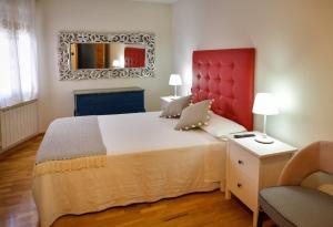 a bedroom with a large bed with a red headboard and a mirror at Villa Teresa in La Bañeza