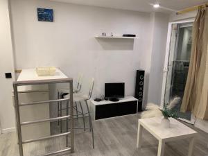 ChiloechesにあるApartamento con piscinaの小さなリビングルーム(デスク、テレビ付)