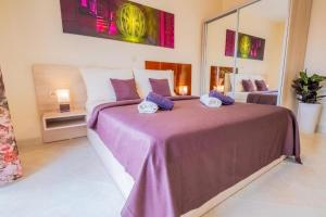 a bedroom with a large bed with purple sheets at La Dama in Novi Vinodolski