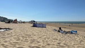 a group of people sitting on the beach at Oostende studio Royal Ascot Q7 met terras en zeezicht op toplocatie in Ostend +3 photos