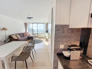 a kitchen and living room with a table and chairs at Oostende studio Royal Ascot Q7 met terras en zeezicht op toplocatie in Ostend