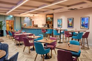 a restaurant with tables and chairs and a bar at Thistle London Piccadilly in London