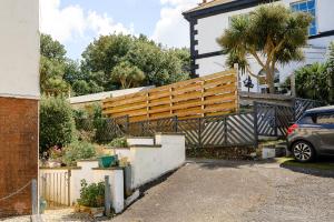 una casa con una valla de madera en una entrada en Coastal Haven Ilfracombe Charming 2-bedroom Cottage In A Great Location, en Ilfracombe