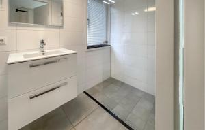 Un baño blanco con lavabo y espejo. en Geheim Van Otterlo, en Otterlo