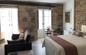 a bedroom with a bed and a chair and a table at Estudios rúa Maior, 49-2A in Sarria