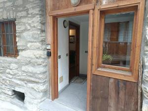 una puerta de madera a un edificio con ventana en The saxe relax in the mountain, en Courmayeur