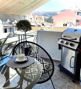patio con mesa y parrilla en el balcón en Diamond City Lux Apartment, en Argostoli