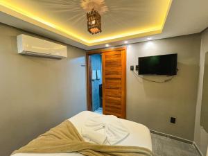 ein Zimmer mit Fernseher und Bett in einem Zimmer in der Unterkunft Milos Hotel Icaraizinho in Icaraí
