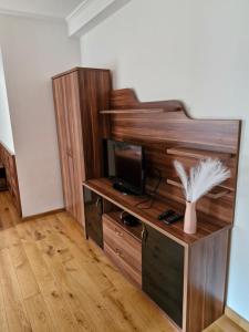 a room with a wooden entertainment center with a tv at Senyői Vendégház in Bózsva