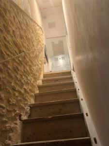 eine Treppe, die zu einem Flur mit einem Kühlschrank führt in der Unterkunft Appartement à 2 pas de la plage in Cabourg