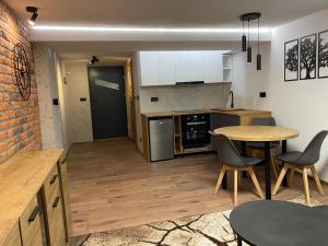 a kitchen and dining room with a table and chairs at Apartament M1 w centrum Wiela in Wiele +16 photos