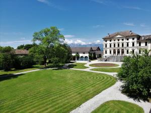 an image of a house with a green yard at Agriturismo Villa di Modolo - Cortile della Latteria in Belluno