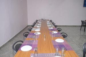 a long long table with plates and wine glasses at Hotel Brij Palace in Sāgar