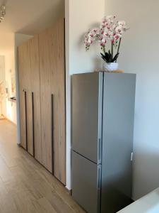 een koelkast met daarop een vaas met bloemen bij Casa SoleLuna in Santa Marinella +8 foto's