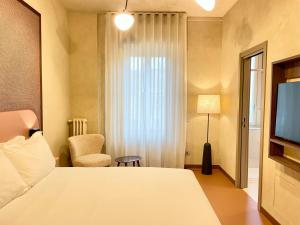 une chambre d'hôtel avec un lit et une télévision dans l'établissement Cà Bèla - Susa, à Milan