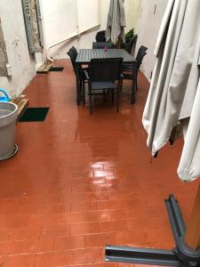 a patio with a table and chairs on a brick floor at Villa des Thermes - T3 rdc in Royat