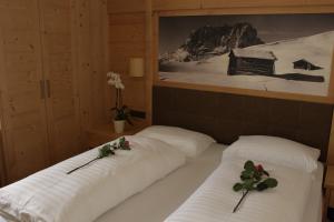two beds in a room with flowers on them at Residence Frea in Selva di Val Gardena