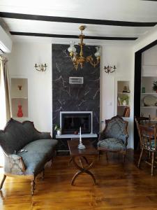a living room with a couch and a fireplace at Διώροφο πέτρινο σπίτι με θέα Agiasos Classic Stone House in Agiásos