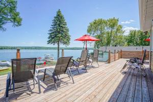 a deck with chairs and umbrellas next to the water at La vie O-Lac Magog in Sherbrooke
