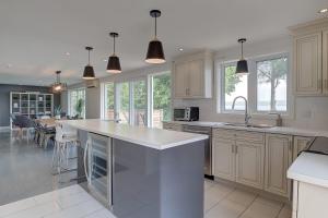 a kitchen with white cabinets and a kitchen island at La vie O-Lac Magog in Sherbrooke +66 photos