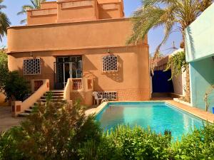 a house with a swimming pool in front of a house at Le Garden Ghardaia in Ghardaïa