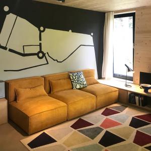 a couch in a living room with a drawing on the wall at Ferienapartment Burgstrasse Ost mit Garten und Sauna in Altleiningen