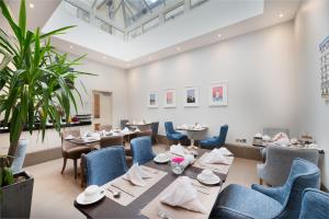 a restaurant with tables and chairs in a room at Gem Langham Court Hotel in London