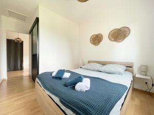 een slaapkamer met een bed met handdoeken erop bij Les chats pitres Maison au calme rénovée avec jardin, terrasse aménagée, transats, abri à vélo, parking gratuit, 5 mn à pied du centre Bayeux proche des plages du débarquement in Bayeux