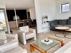 ein Wohnzimmer mit Sofa, Stühlen und einem Tisch in der Unterkunft Het Duintje in Egmond aan Zee