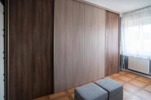 a room with a bench and a wooden wall at Panoráma Apartman in Miskolc