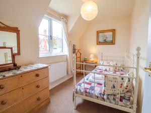 a bedroom with a bed and a dresser and a window at 1 Market Hill in Woodbridge