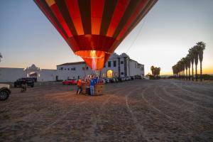 a hot air balloon flying over a dirt field at Convento da Orada - Monsaraz in Monsaraz