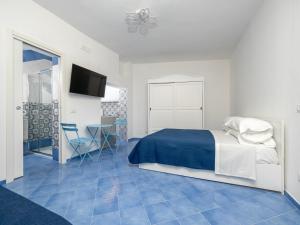 a bedroom with a bed and a blue tile floor at De Vivo Realty - Camilla House Positano in Positano