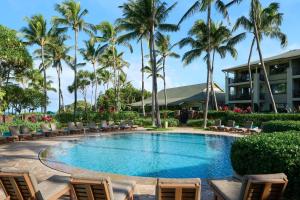 a pool at the resort with chairs and palm trees at The Ritz-Carlton O'ahu, Turtle Bay in Kahuku