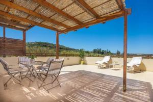 Un patio con sillas y una mesa en una terraza. en Villa Mandarin Platanias, en Plataniás