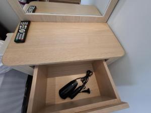 ein kleines Holzregal mit einer Fernbedienung darin in der Unterkunft One bedroom gold coast pik in Jakarta