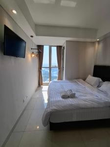 ein Schlafzimmer mit einem Bett mit zwei Handtüchern darauf in der Unterkunft One bedroom gold coast pik in Jakarta