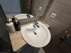ein Badezimmer mit einem weißen Waschbecken und einem Spiegel in der Unterkunft One bedroom gold coast pik in Jakarta + 5 Fotos