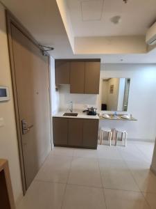 eine offene Küche mit zwei weißen Stühlen und einem Tisch in der Unterkunft One bedroom gold coast pik in Jakarta