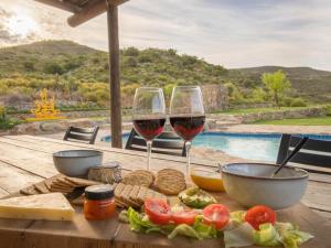 two glasses of wine on a wooden table with food at Ludicks Farm in Montagu