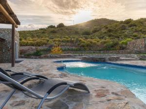 a swimming pool with a lounge chair in the foreground at Ludicks Farm in Montagu